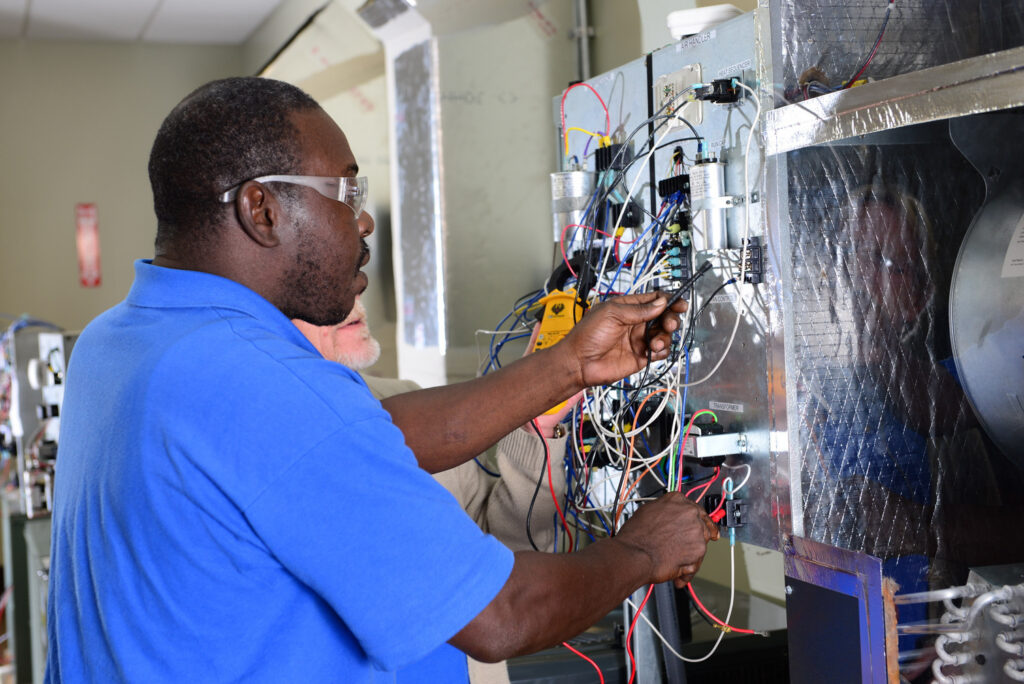 Technician examining HVAC circuitry