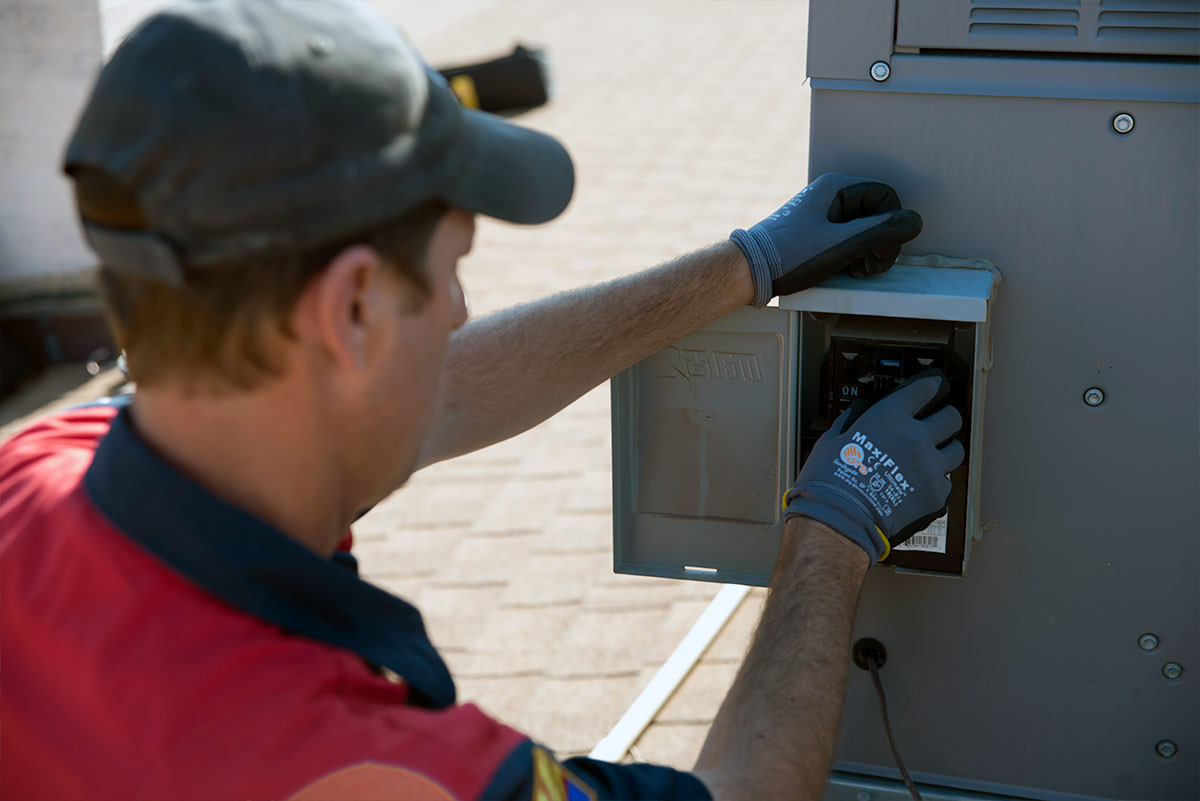 hvac technician working on ac electric panel