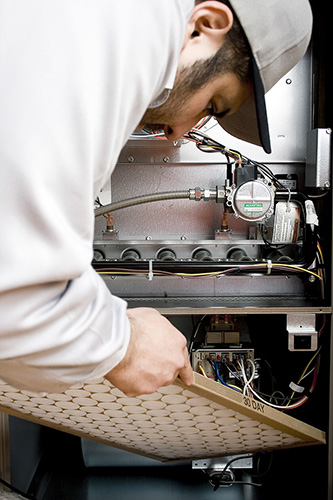 hvac technician changing a furnace filter