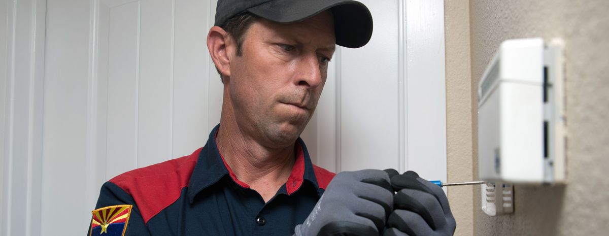 hvac technician installing smart thermostat