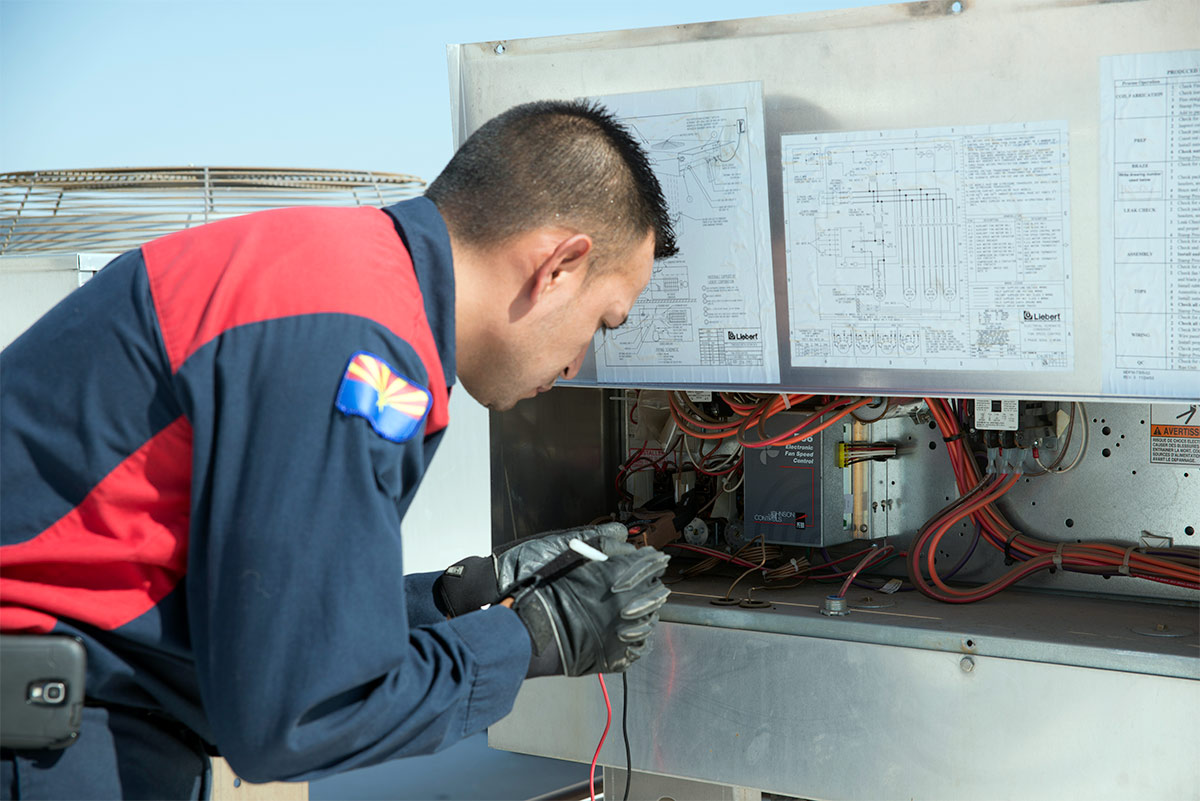 hvac tech performing ac maintenance